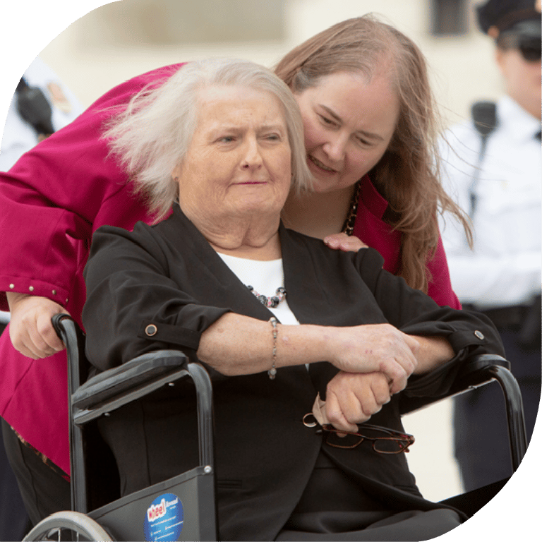 One woman whispering in another woman's ear